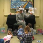 Woman dressed as elephant reading to children