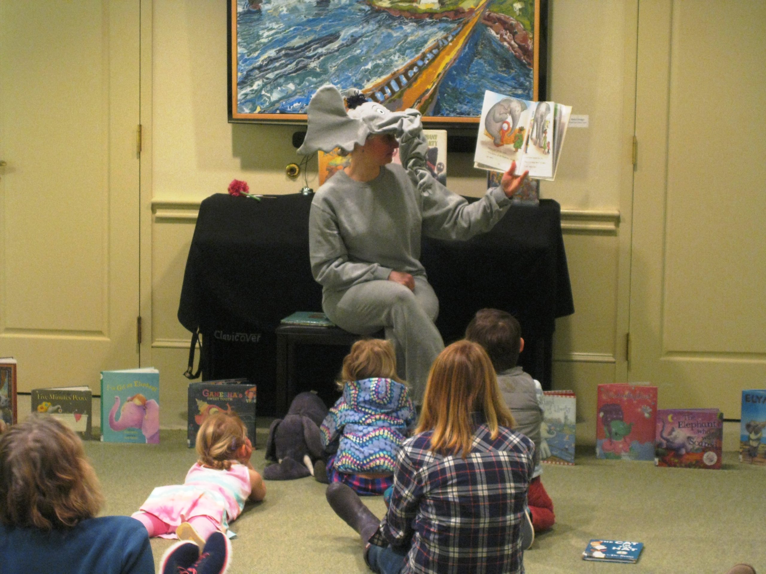 Woman dressed as elephant reading to children