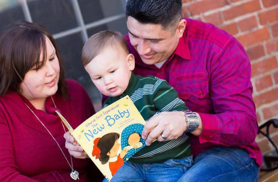 parents with baby reading book